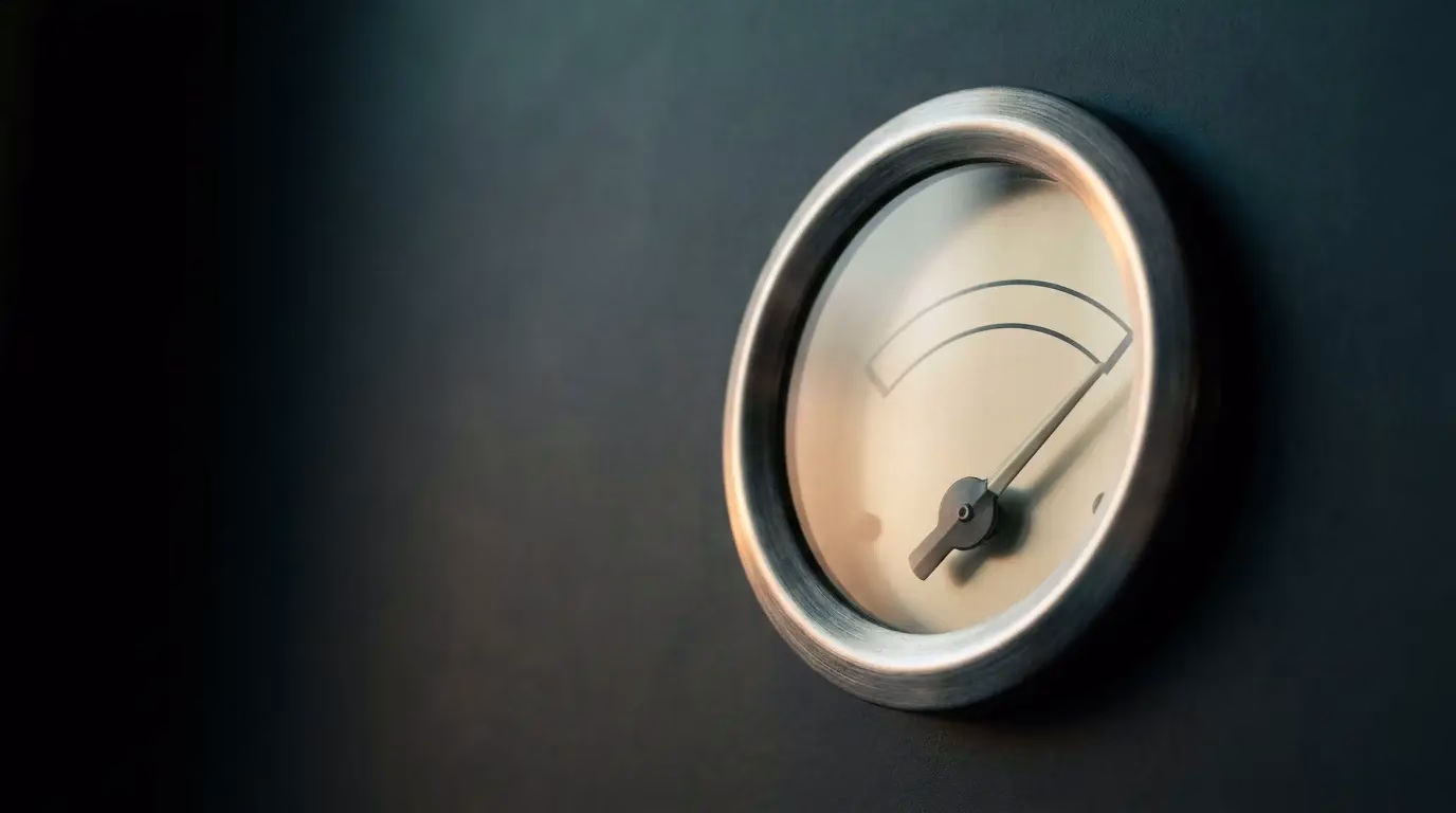 Vintage fuel gauge with the needle short of full, showing spare capacity, representing the load buffer